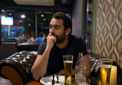 Thomas assis à une table d'un bar